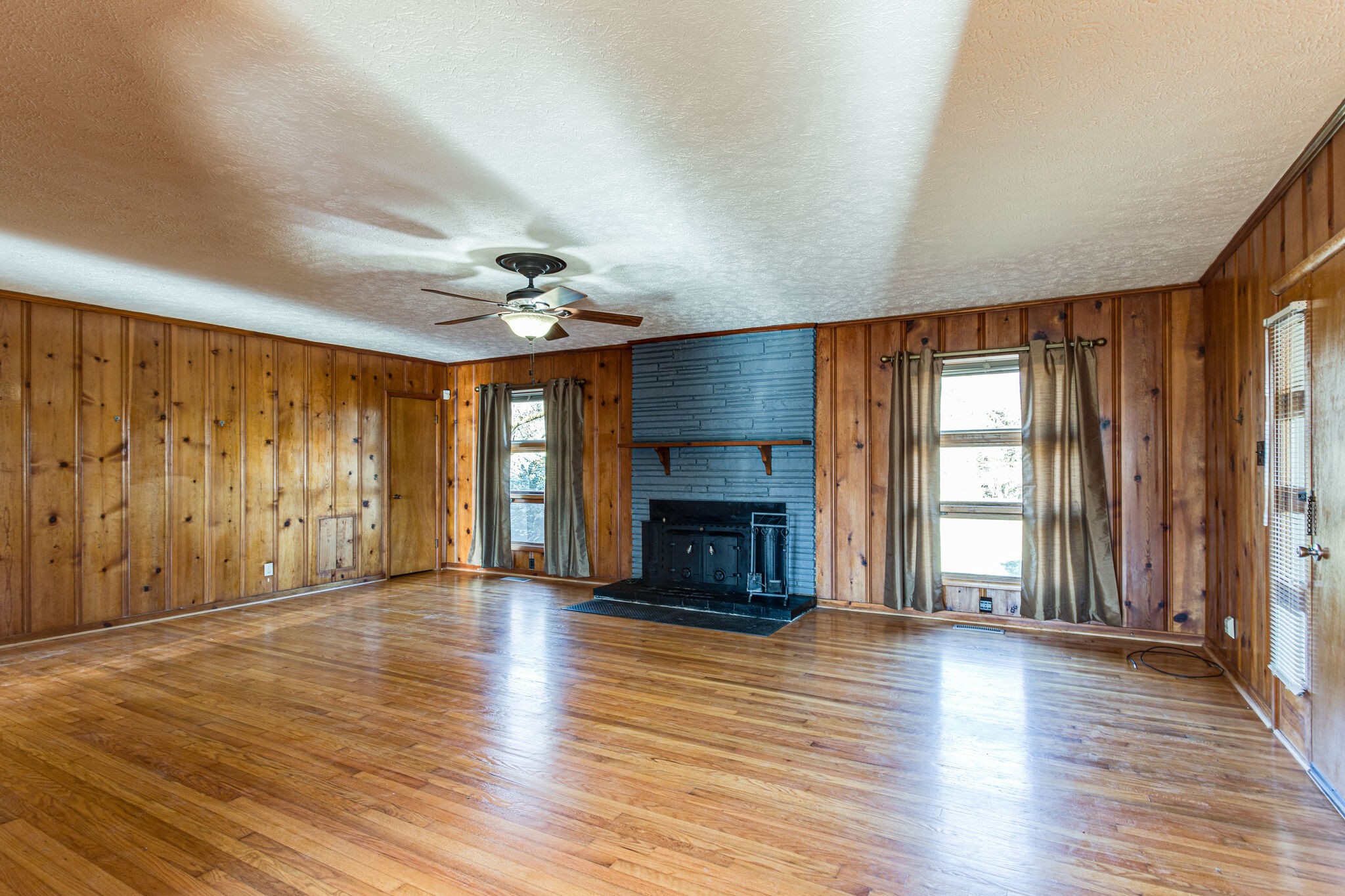 404 Monroe Floyd Road Decherd, TN 37324 - Photo 10 of 44 an empty room with wooden floor fireplace and windows