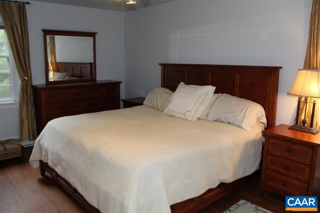 1724 Old Forge Road Charlottesville, VA 22901 - Photo 11 of 30 a large bed sitting in a bedroom next to a lamp with a dresser and a lamp