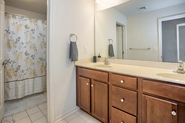 a bathroom with a double vanity sink mirror and shower