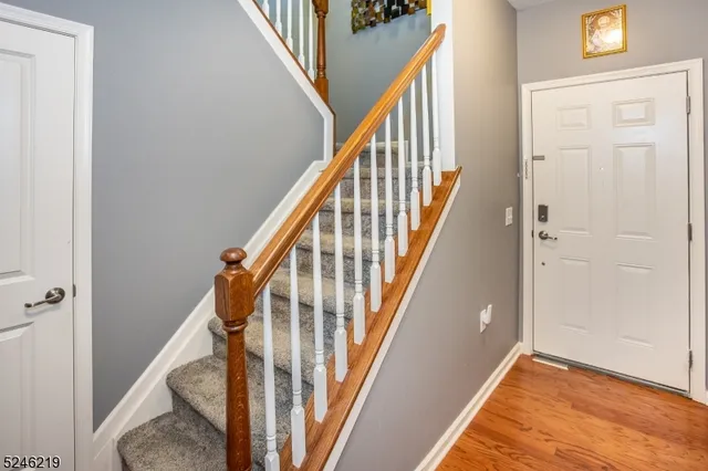 a view of a hallway with wooden floor and staircase