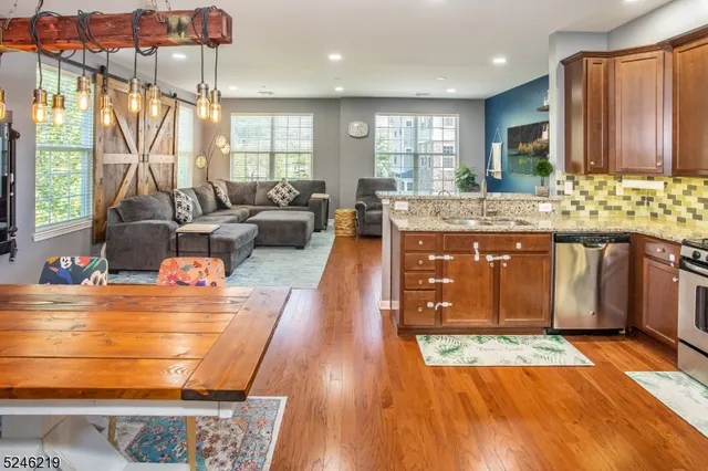 a kitchen with stainless steel appliances granite countertop a stove and a wooden floors