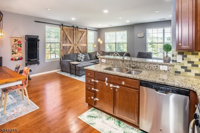 a kitchen with stainless steel appliances granite countertop sink cabinets and wooden floor