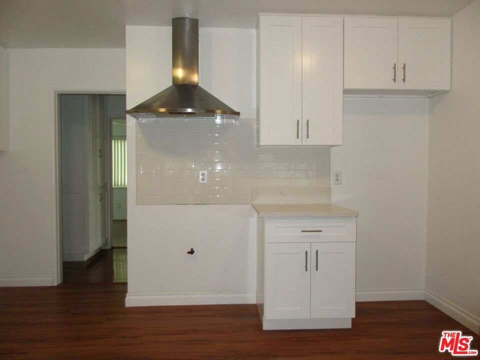 719 East 154th Street Compton, CA 90220 - Photo 12 of 32 a view of a kitchen with granite countertop white cabinets and a wooden floor