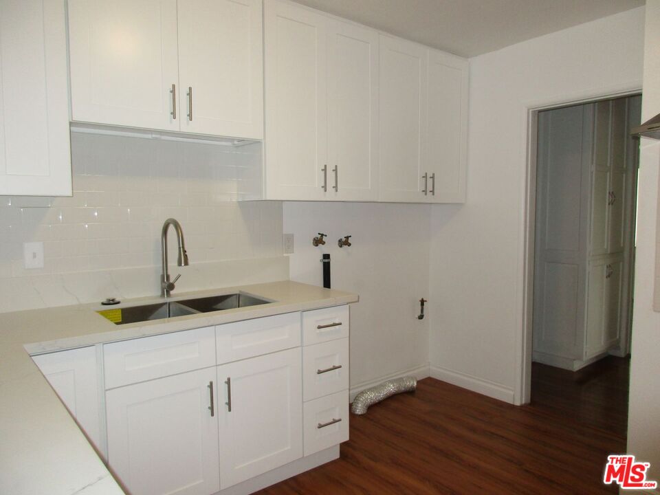 719 East 154th Street Compton, CA 90220 - Photo 13 of 32 a kitchen with a sink cabinets and wooden floor