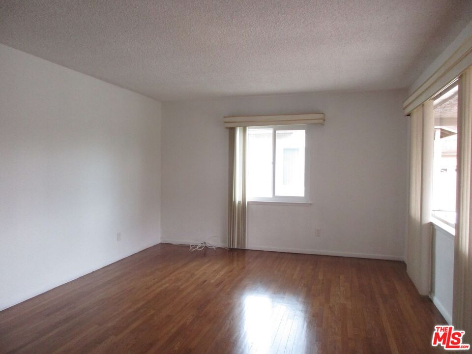 719 East 154th Street Compton, CA 90220 - Photo 3 of 32 an empty room with wooden floor and windows
