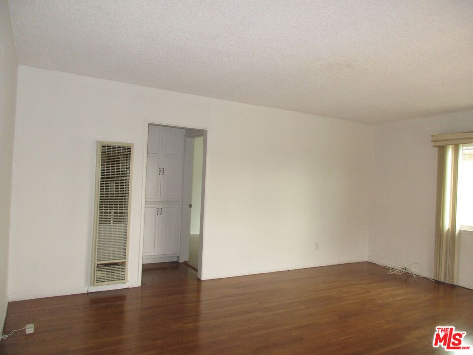 719 East 154th Street Compton, CA 90220 - Photo 5 of 32 an empty room with wooden floor and windows