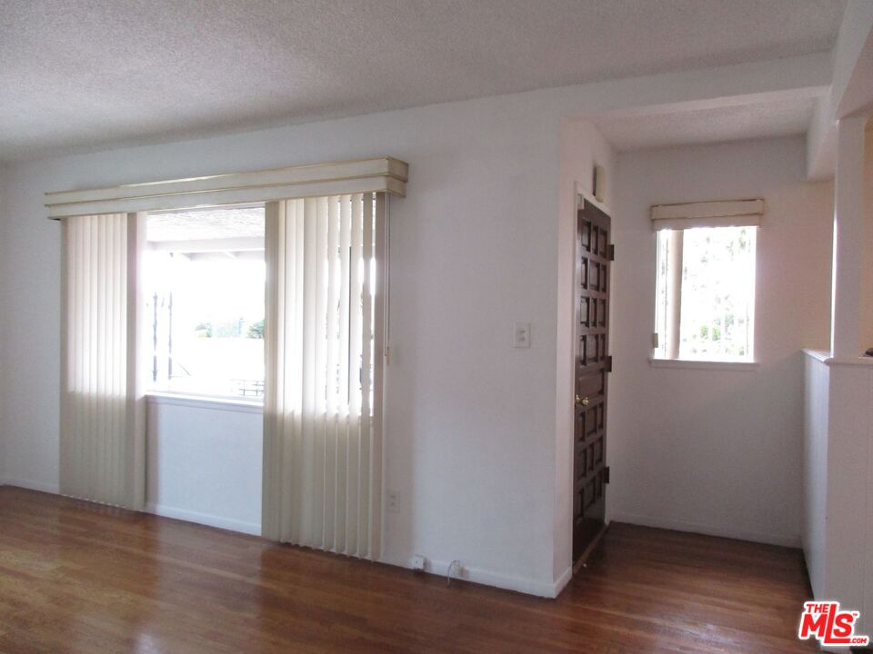 719 East 154th Street Compton, CA 90220 - Photo 6 of 32 an empty room with wooden floor and windows