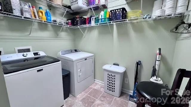 a utility room with dryer washer and shoe rack