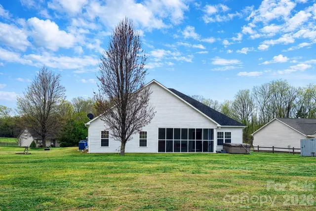 a view of a big house with a big yard and large trees