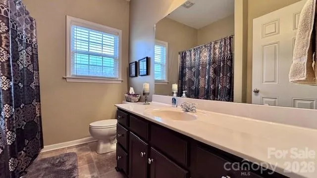 a bathroom with a sink a toilet a mirror and shower