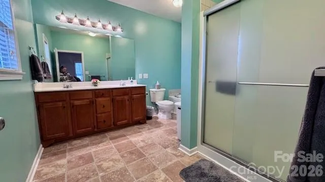 a spacious bathroom with a double vanity sink a toilet and a mirror