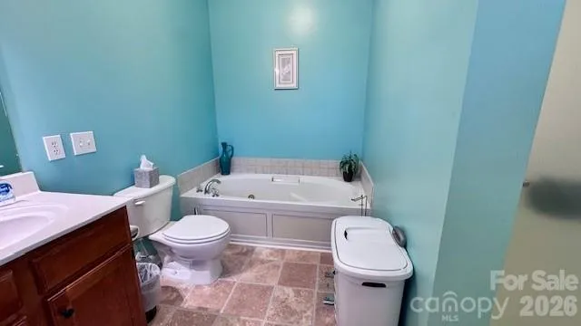 a white toilet sitting next to a bathroom sink and a mirror