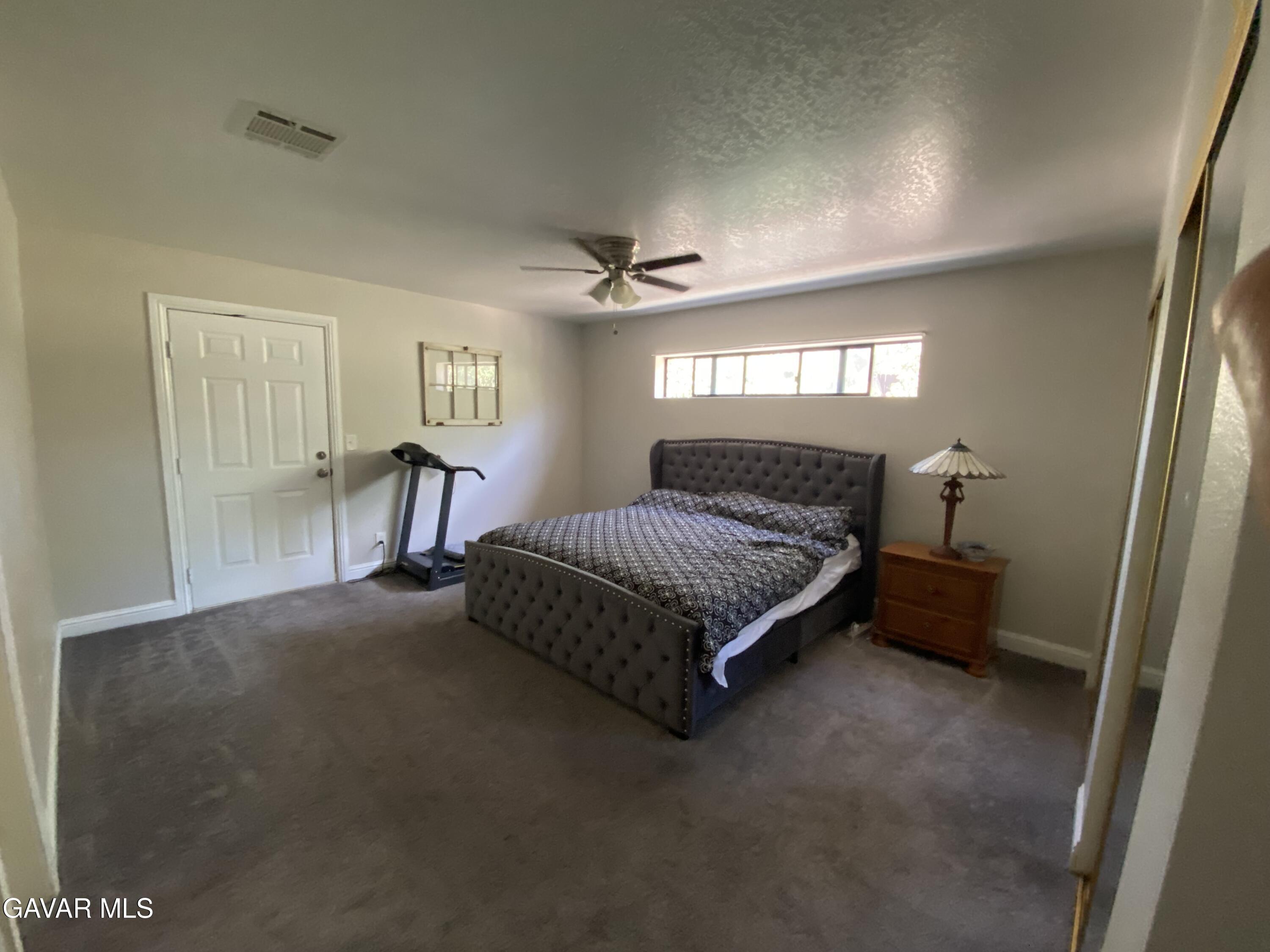 20909 Ridgeway Drive Tehachapi, CA 93561 - Photo 11 of 13 a bedroom with a bed and a chandelier