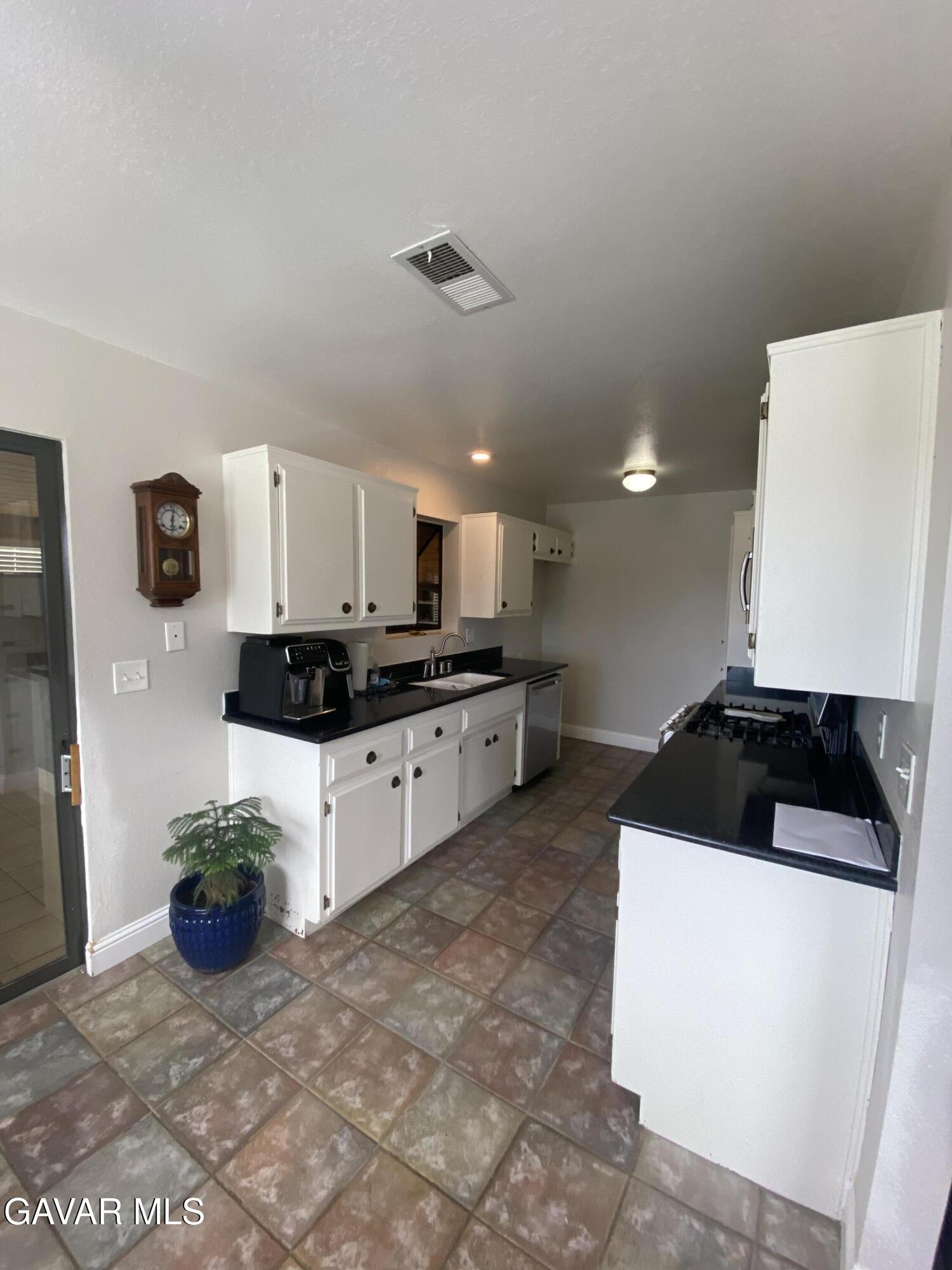 20909 Ridgeway Drive Tehachapi, CA 93561 - Photo 5 of 13 a kitchen with a refrigerator and a stove top oven