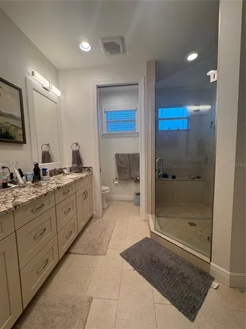 a spacious bathroom with a mirror a shower and a sink