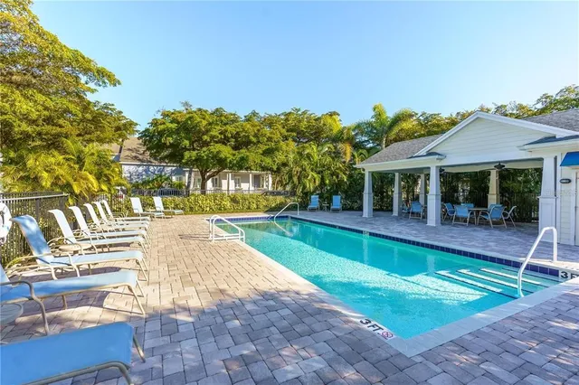 a view of swimming pool with lawn chairs and plants