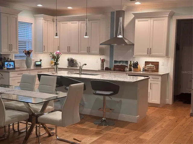 a kitchen with a sink chairs and cabinets
