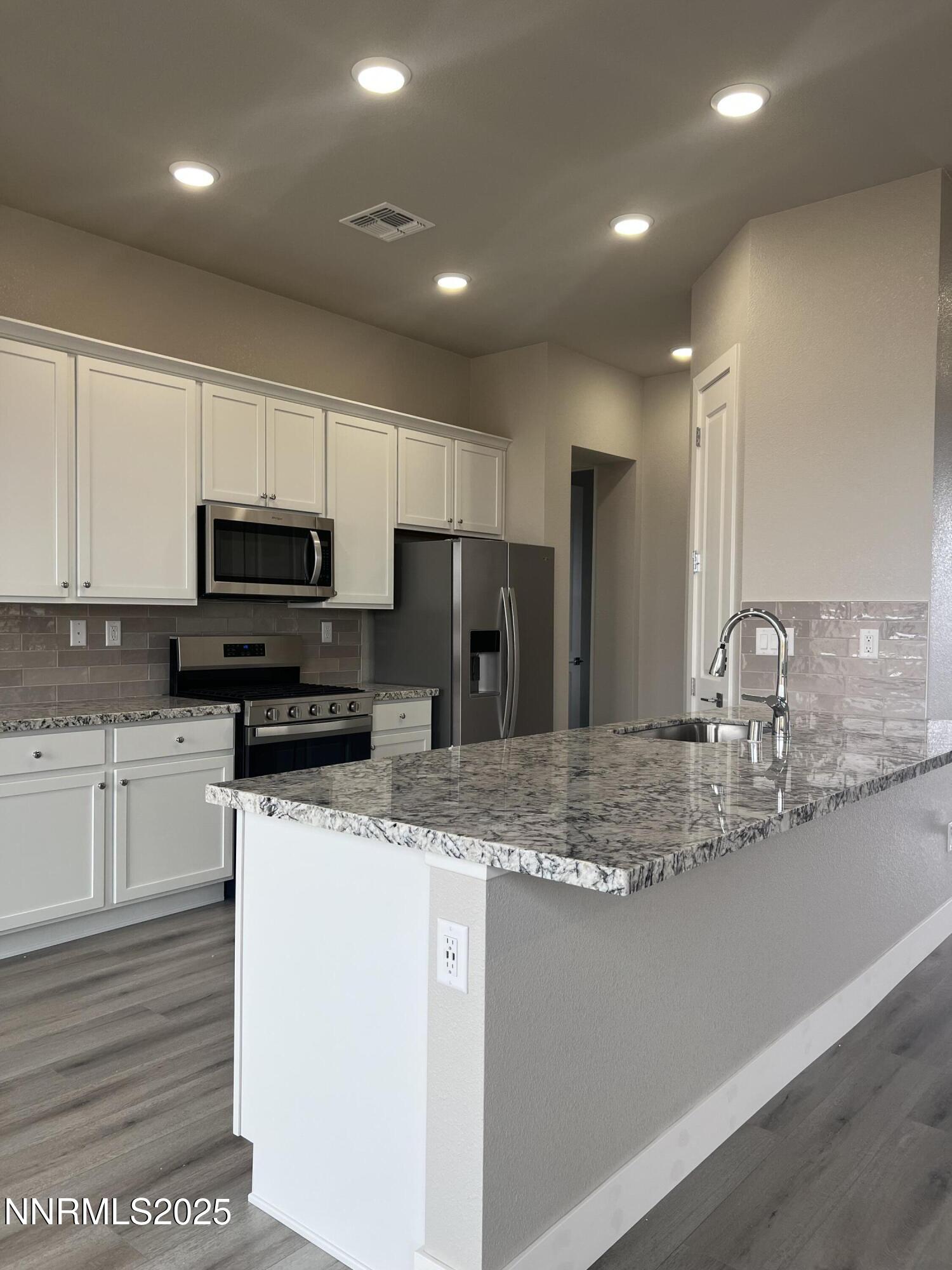 14430 Fredonia Drive Reno, NV 89506 - Photo 7 of 9 a kitchen with stainless steel appliances granite countertop a sink a stove a microwave and a refrigerator