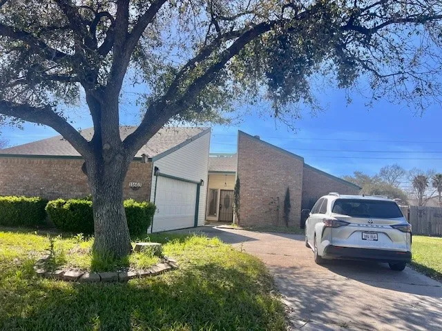 a car parked in front of a house with wooden fence
