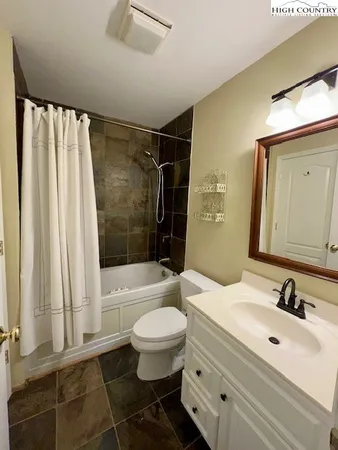a bathroom with a sink toilet a mirror and shower