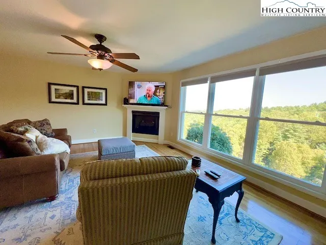 a living room with furniture a flat screen tv and a large window