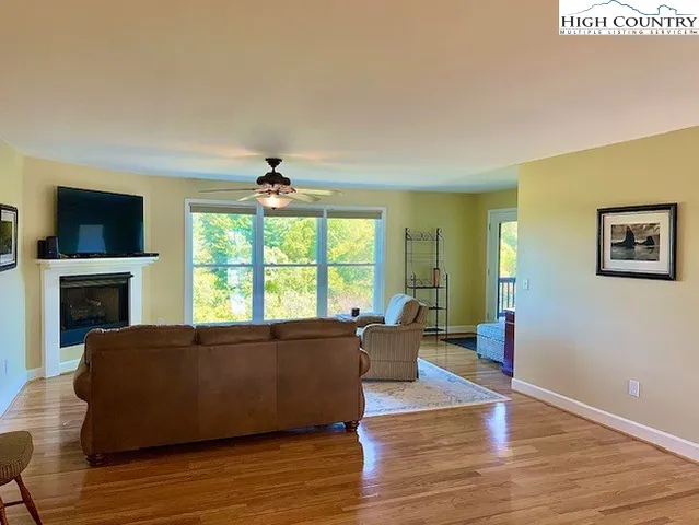 a living room with furniture a large window and a fireplace