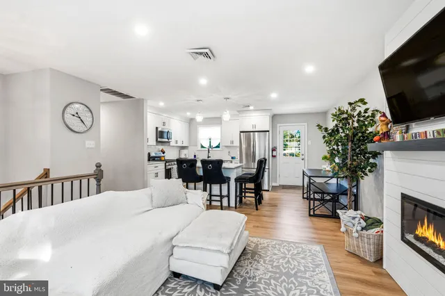 a large kitchen with stainless steel appliances granite countertop a stove a sink dishwasher and a refrigerator with wooden floor