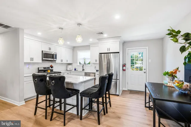 a kitchen with cabinets appliances a sink and a window