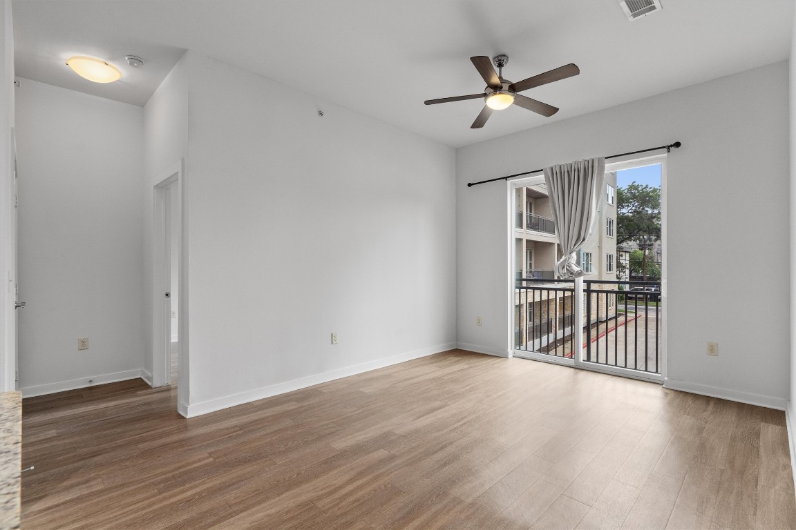 1900 Barton Springs Road, Unit 2027 Austin, TX 78704 - Photo 11 of 28 Unfurnished room with light wood-style floors and ceiling fan