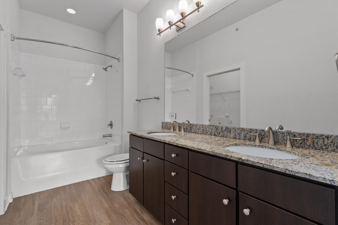 1900 Barton Springs Road, Unit 2027 Austin, TX 78704 - Photo 15 of 28 Bathroom featuring double vanity, light wood-style flooring, a walk in closet, washtub / shower combination, and recessed lighting