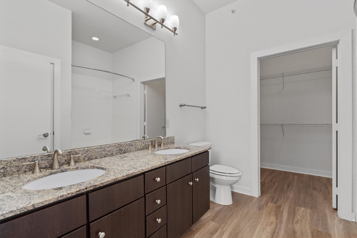 1900 Barton Springs Road, Unit 2027 Austin, TX 78704 - Photo 20 of 28 Full bathroom featuring double vanity, light wood-style flooring, a shower, and a walk in closet
