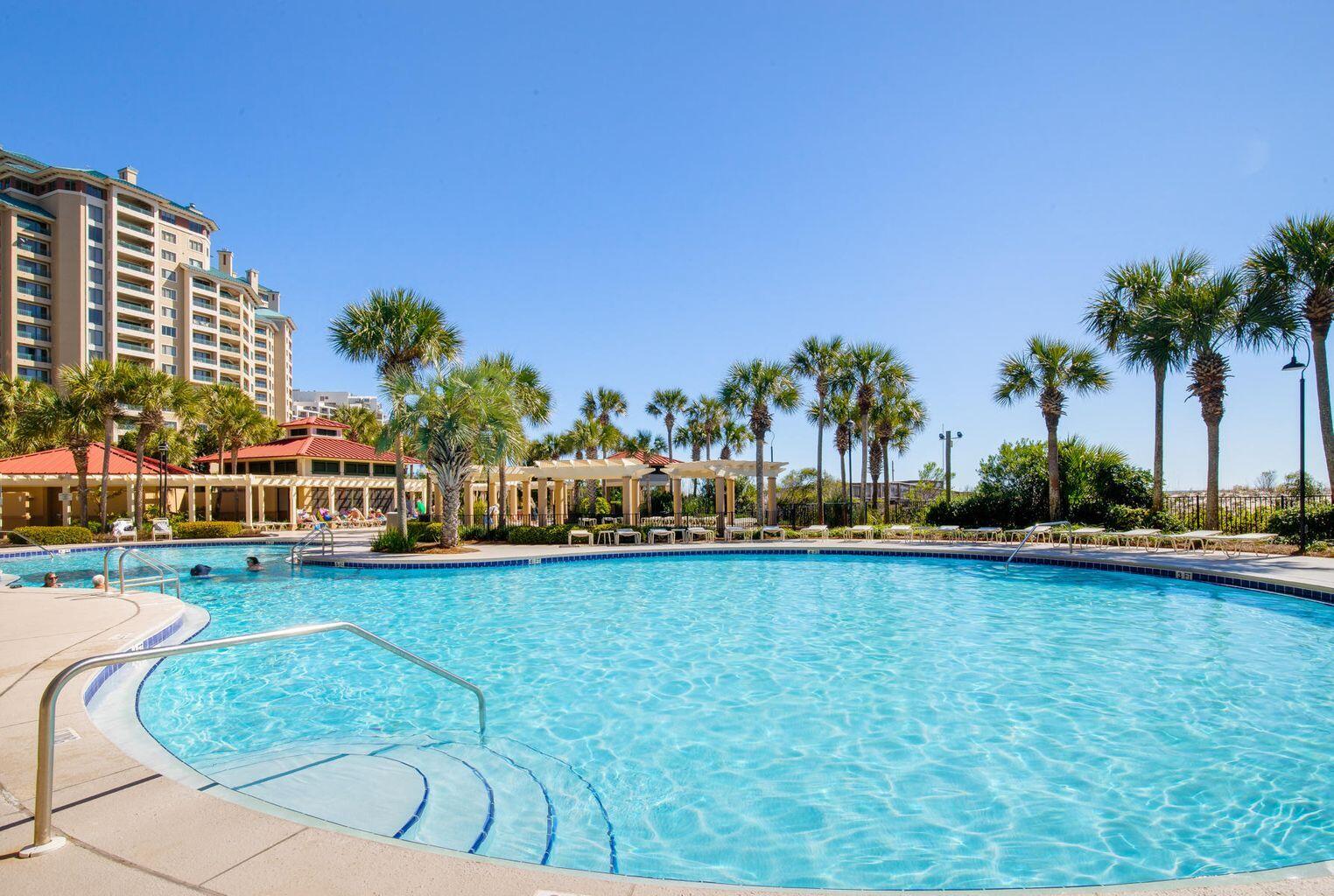 4789 Westwinds Drive, Unit 4789 Miramar Beach, FL 32550 - Photo 27 of 32 a view of swimming pool with outdoor seating and trees in the background
