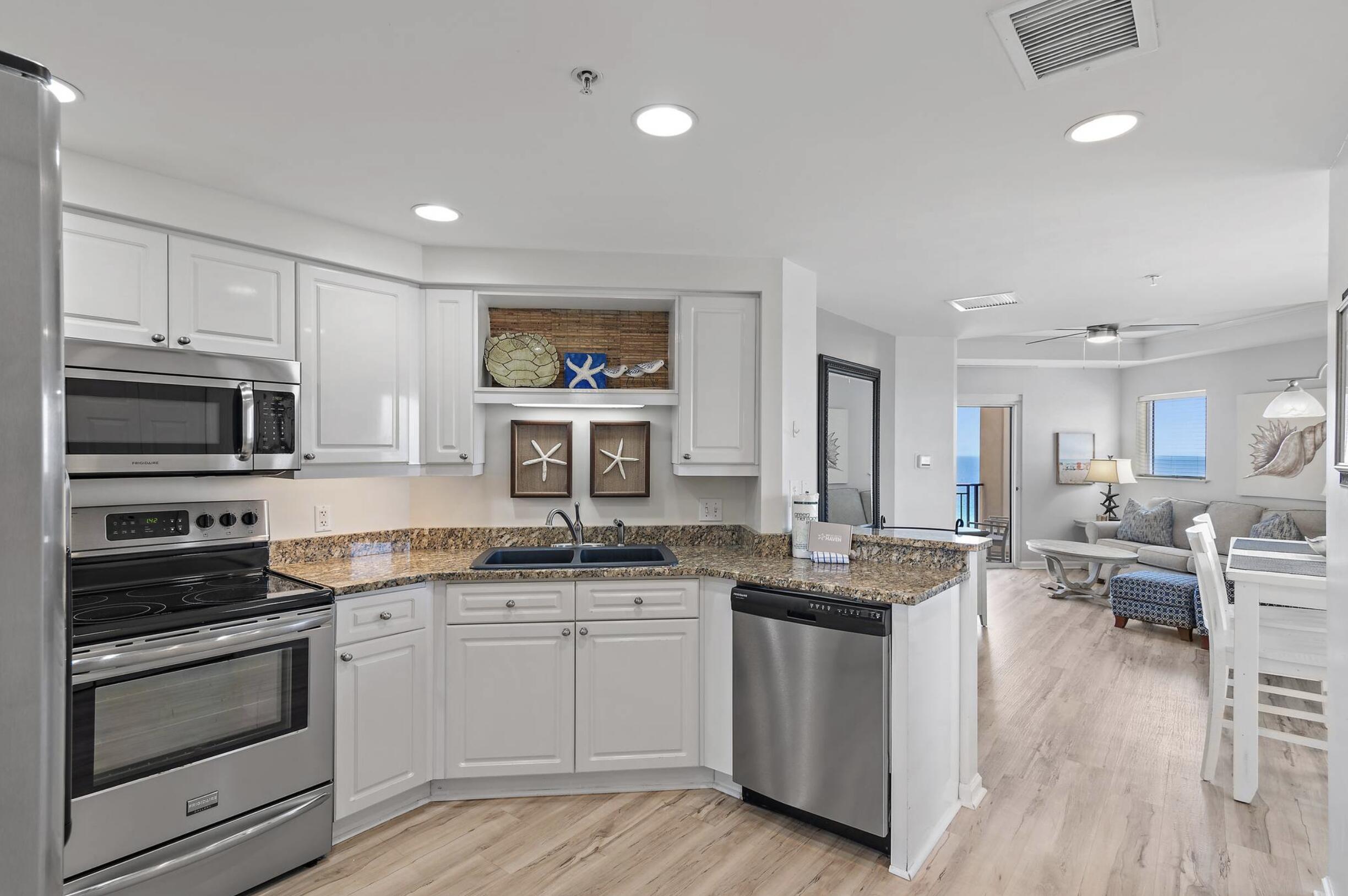 4789 Westwinds Drive, Unit 4789 Miramar Beach, FL 32550 - Photo 5 of 32 a kitchen with stainless steel appliances a stove sink microwave and cabinets