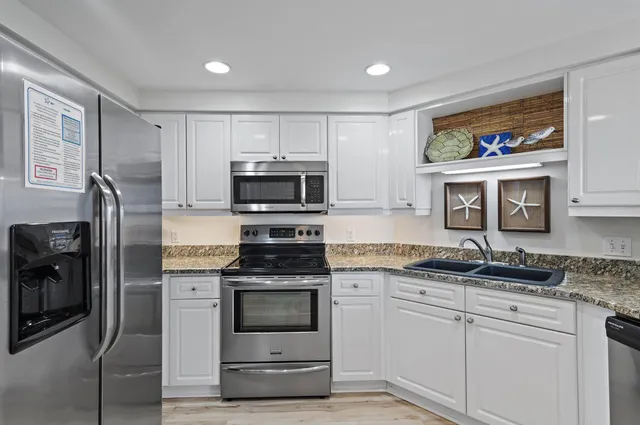 a kitchen with stainless steel appliances granite countertop a stove a sink and a refrigerator