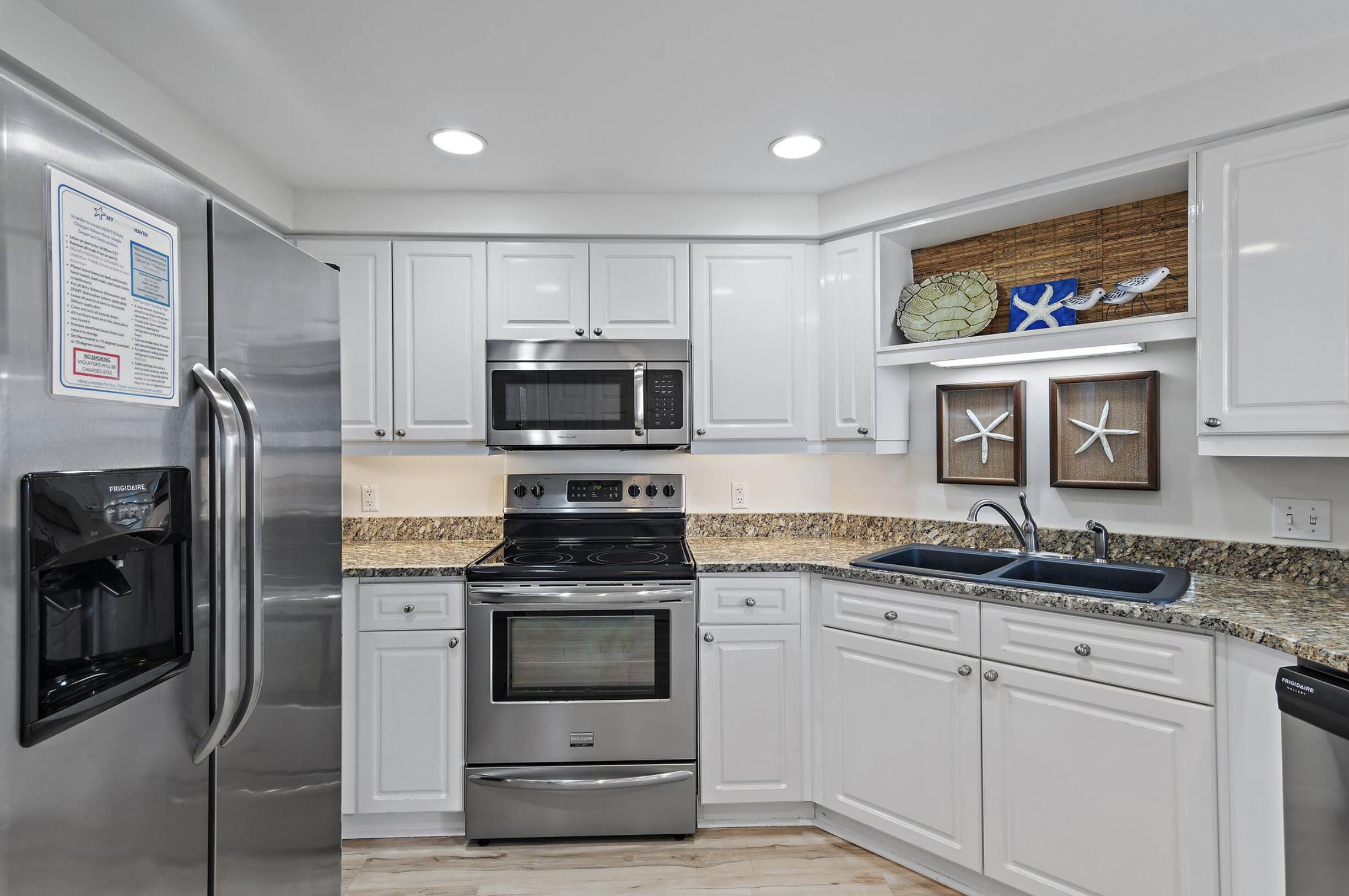 4789 Westwinds Drive, Unit 4789 Miramar Beach, FL 32550 - Photo 7 of 32 a kitchen with stainless steel appliances granite countertop a stove a sink and a refrigerator