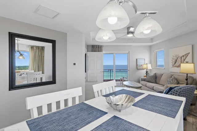 a living room with furniture and a large mirror next to a window