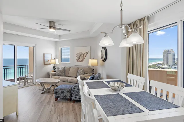 a living room with furniture a large window and wooden floor