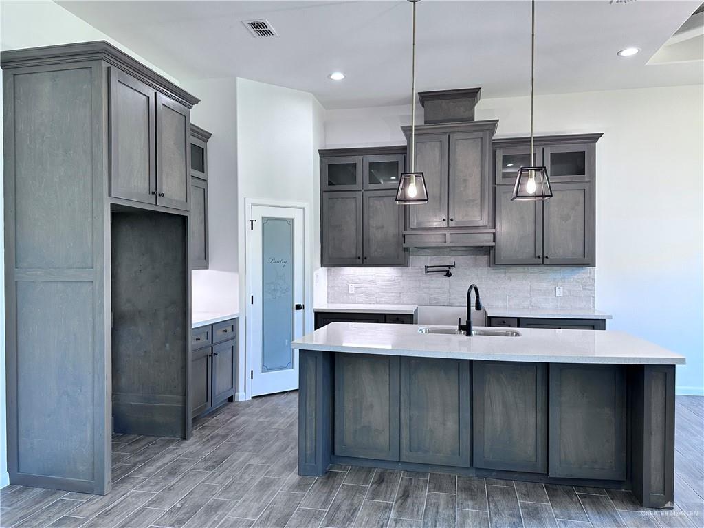 1100 Azalea Street Mission, TX 78573 - Photo 11 of 24 a kitchen with kitchen island granite countertop a sink cabinets and stainless steel appliances