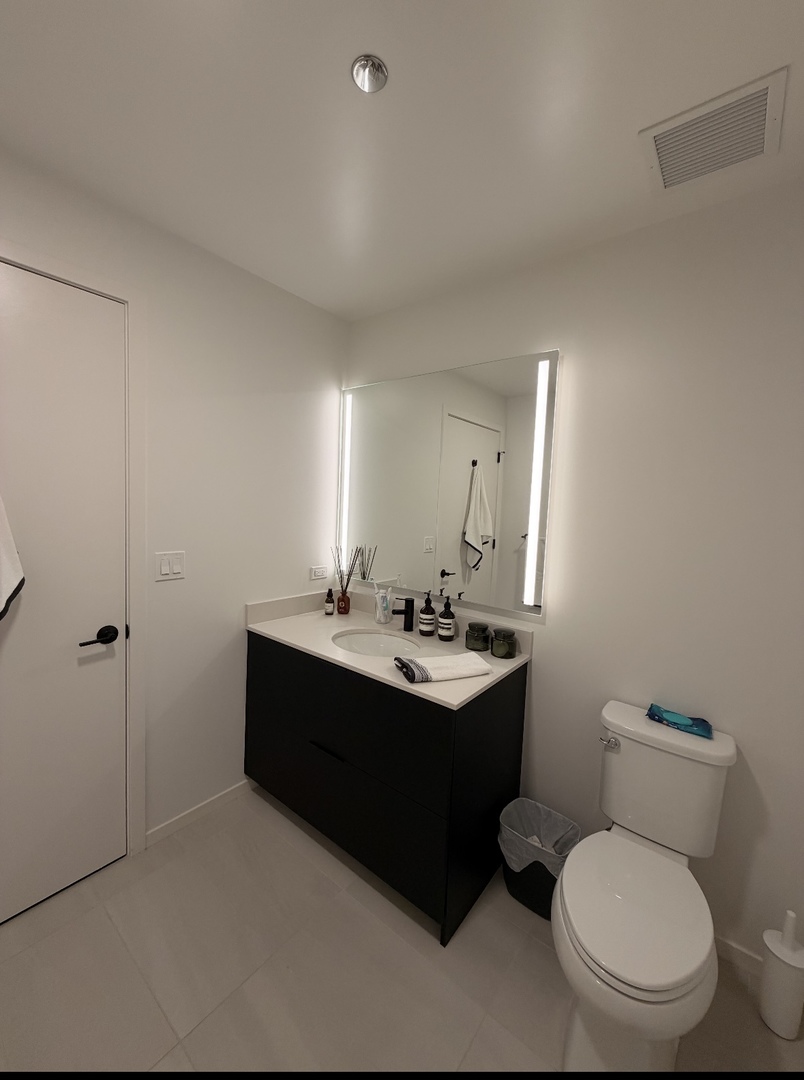 225 North Elizabeth Street, Unit 514 Chicago, IL 60607 - Photo 13 of 13 a bathroom with a toilet a sink and mirror