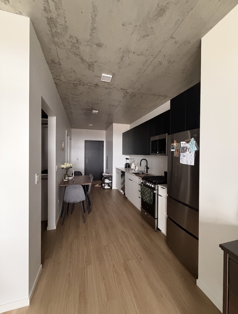 225 North Elizabeth Street, Unit 514 Chicago, IL 60607 - Photo 5 of 13 a kitchen with stainless steel appliances granite countertop a refrigerator oven a sink dishwasher and a stove with wooden floor