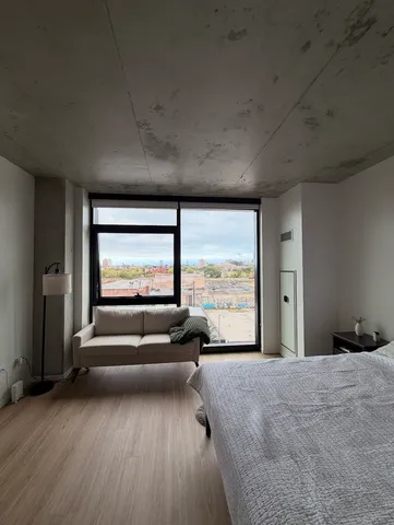 a bedroom with a bed and large windows