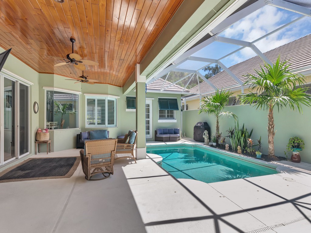 a view of a patio with table and chairs potted plants and floor to ceiling window and potted plants