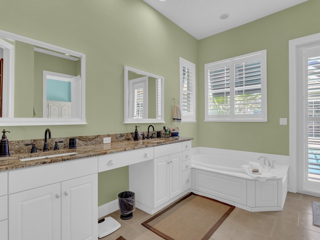 9220 Spring Time Drive Vero Beach, FL 32963 - Photo 12 of 28 a bathroom with a tub sink double vanity granite and a bathtub
