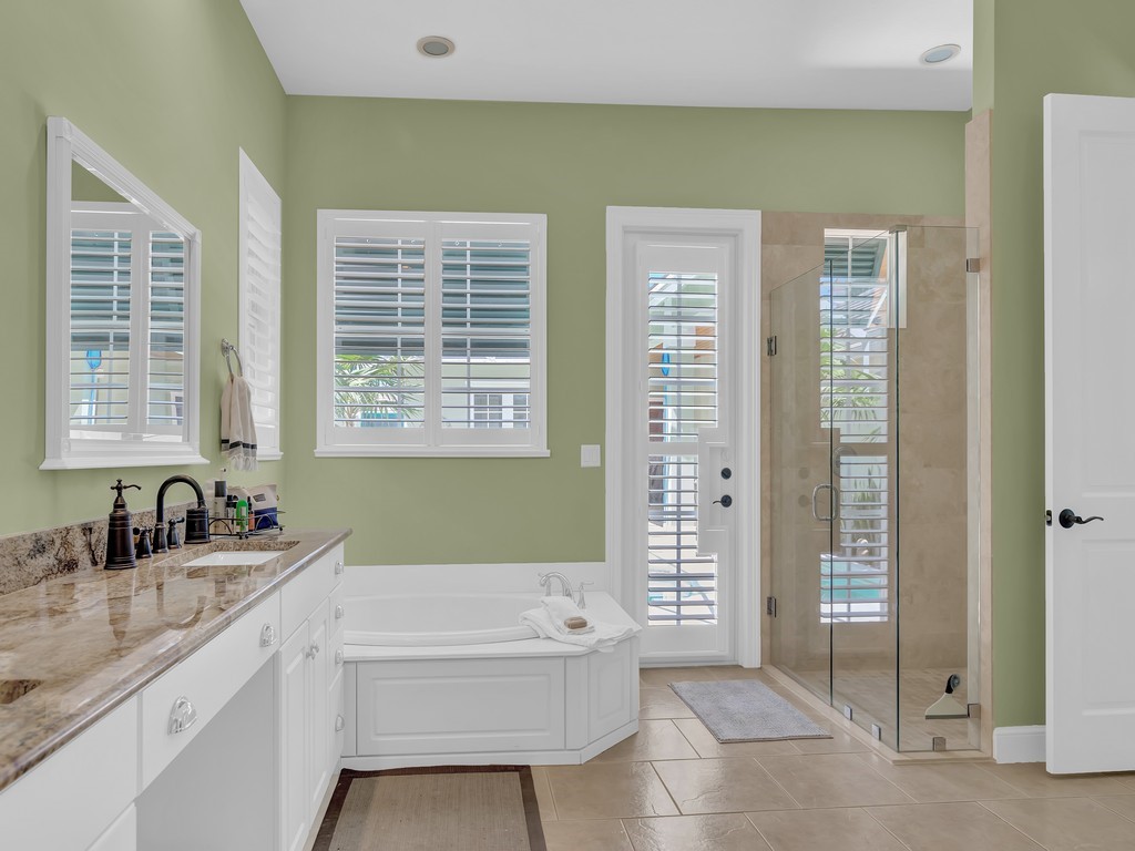 9220 Spring Time Drive Vero Beach, FL 32963 - Photo 13 of 28 a bathroom with a granite countertop tub a sink and a shower
