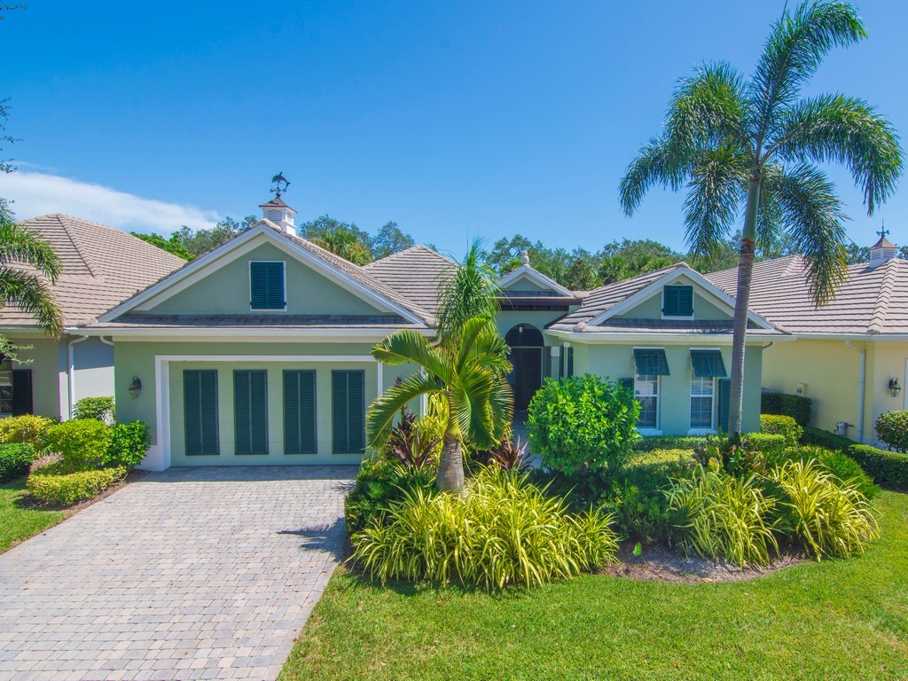9220 Spring Time Drive Vero Beach, FL 32963 - Photo 2 of 28 a front view of a house with a garden
