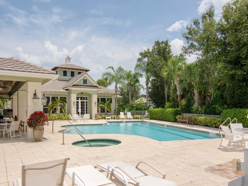 9220 Spring Time Drive Vero Beach, FL 32963 - Photo 26 of 28 a view of a white house with a big yard and potted plants