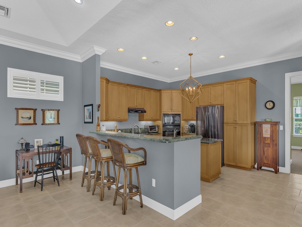 9220 Spring Time Drive Vero Beach, FL 32963 - Photo 5 of 28 a kitchen with refrigerator and chairs