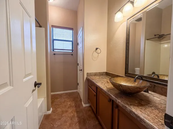 a bathroom with a granite countertop sink and a mirror