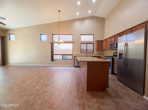 a kitchen with stainless steel appliances granite countertop a refrigerator a sink and a stove