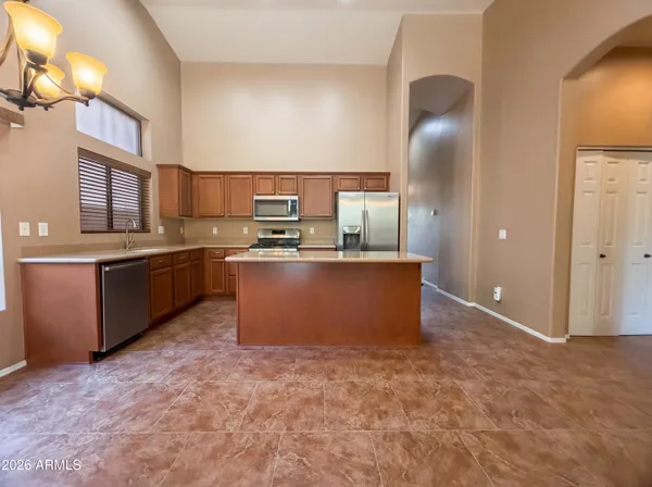 a kitchen with stainless steel appliances granite countertop a stove a sink a refrigerator and island